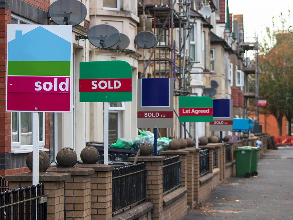 Estate agents' sold boards along a residential street
